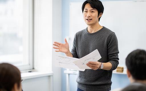 大田区の教室でマーケティング資料を手に説明する日本人講師